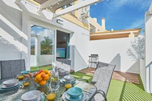 ein Esszimmer mit einem Tisch und Stühlen auf einer Terrasse in der Unterkunft VILLA by the beach. Pool, Priv Parking and Golf in Torre de Benagalbón