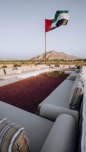 八田Hatta resort farmstay & activities Hiking and more的摆在有枕头的建筑物屋顶上的旗帜