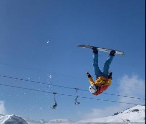 una persona en una tabla de snowboard haciendo un truco en el aire en Apart Jil-Marie Studio 7, en Samnaun