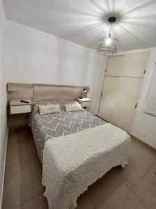 1 dormitorio con 1 cama, 2 mesas y luz en Departamento nuevo, planta baja, con patio en Santiago del Estero