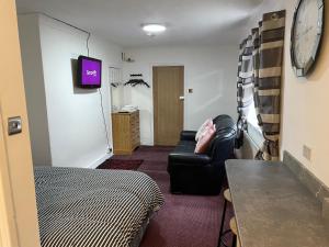 a living room with a couch and a tv at Apartments Azalea Terrace in Sunderland