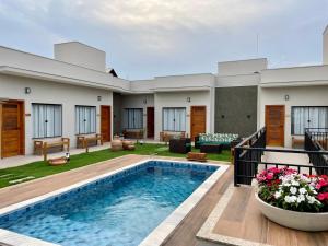uma villa com uma piscina e uma casa em Pousada Saudadocê em São José da Barra
