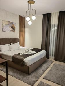 a bedroom with a bed and a chandelier at Cordoba suites Penthouse with private open air Jacuzzi in Hurghada