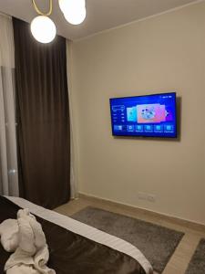 a bedroom with a tv on the wall and a bed at Cordoba suites Penthouse with private open air Jacuzzi in Hurghada