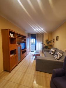 - un salon avec un canapé et une télévision dans l'établissement Santa Catalina Queen, à Las Palmas de Gran Canaria
