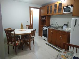 een kleine keuken met een tafel en een koelkast bij Apartamento Tomasini in Gramado