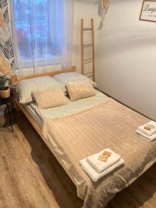 1 dormitorio con 1 cama con toallas en Apartamenty Wierzbiny nad jeziorem numer 2, 
