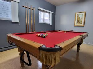 a pool table with a red cover in a room at Auberge Soleil de Mer in Bonaventure