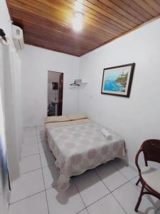 a bedroom with a bed and a chair in it at Suíte agradável no centro da cidade. in Boa Vista