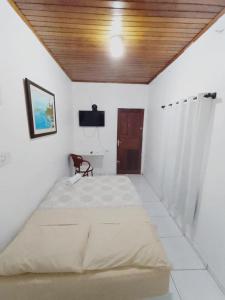 1 dormitorio con 1 cama grande y techo de madera en Suíte agradável no centro da cidade., en Boa Vista