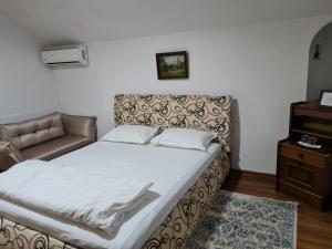 a bedroom with a bed and a couch and a table at Pensiunea Clasic in Gherla