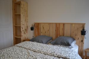 een slaapkamer met een groot bed met 2 kussens bij Maison Sottou in Osse-en-Aspe