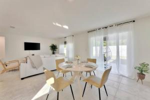 una sala de estar blanca con mesa y sillas en Serene Sarasota Residence * By th Beach & Airport! en Sarasota