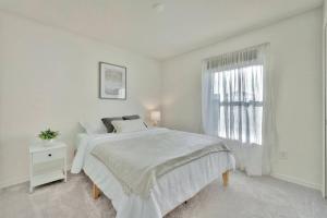 a white bedroom with a white bed and a window at Serene Sarasota Residence * By th Beach & Airport! in Sarasota