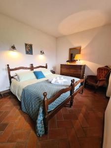 a bedroom with a large bed and a chair at La casa di MonAmì in Spello