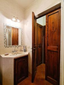 uma casa de banho com um lavatório e uma porta de madeira em La casa di MonAmì em Spello