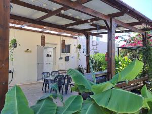 a patio with a table and chairs under a wooden pergola at House Near The Beach (Militsa & Aggeliki) in Pervolia