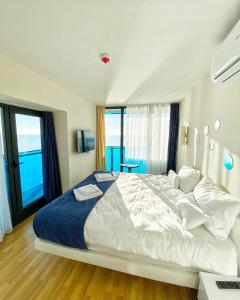 a bedroom with a large bed with a large window at Batumi Orbi City Lux Apartment 5* in Batumi