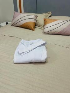 a white shirt sitting on top of a bed at Kit perfeita no Park Sul in Brasilia