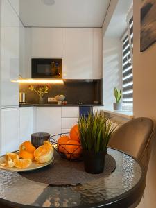 - une cuisine avec une table et des oranges dans l'établissement Alyvų tako studija, à Alytus