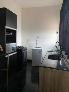 a small kitchen with a sink and a refrigerator at Pousada Corumba Center in Corumbá