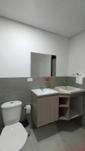ein Badezimmer mit einem WC, einem Waschbecken und einem Spiegel in der Unterkunft Apto en Zona Turística de Popayán in Popayan