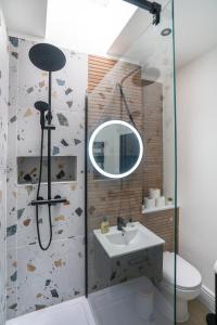 ein Bad mit einem Waschbecken und einer Dusche mit einem Spiegel in der Unterkunft Luxury Apartment - Portobello in Edinburgh