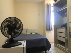 a bedroom with a bed with a fan on a dresser at Quarto privativo in Campina Grande