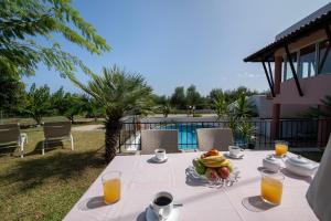 a table with a bowl of fruit and orange juice at Villa Eleni 100m from the sea in Ropanianá