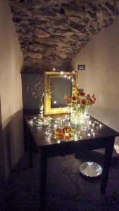 een tafel met een spiegel en bloemen erop bij DANTES in Pieve di Teco
