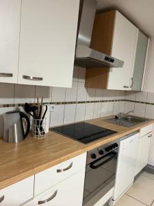 a kitchen with white cabinets and a stove top oven at Holiday Homes 1 in Monzingen