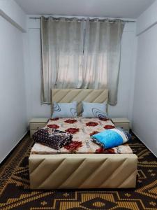a bedroom with a large bed with blue pillows at Family House in Agadir