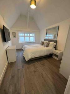 The Swan Apartment Ruislip في ريوسليب: غرفة نوم بسرير كبير وأرضيات خشبية
