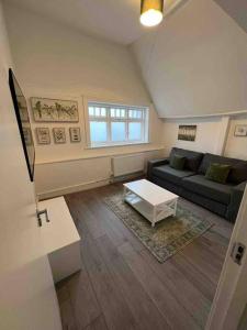 a living room with a couch and a coffee table at The Swan Apartment Ruislip in Ruislip