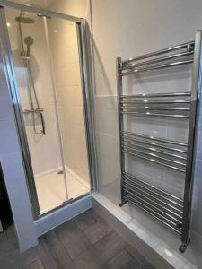 La salle de bains est pourvue d'une douche avec une porte en verre. dans l'établissement The Swan Apartment Ruislip, à Ruislip