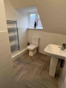 a bathroom with a toilet and a sink at The Swan Apartment Ruislip in Ruislip