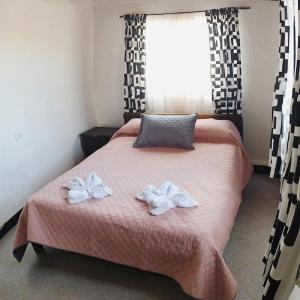 una camera da letto con un letto con due asciugamani bianchi di Aparta Hotel Bella Vista a Choachí