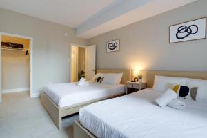 duas camas num quarto de hotel com lençóis brancos em Great Condo for a Comfortable Stay @Crystal City em Arlington