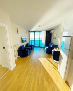 a living room with blue couches and a wooden floor at Batumi Orbi City Lux Apartment 5* in Batumi