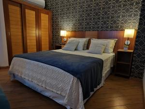 a bedroom with a large bed with a blue blanket at São Paulo Mercure Moema Times Square - Flat DIAMOND in São Paulo