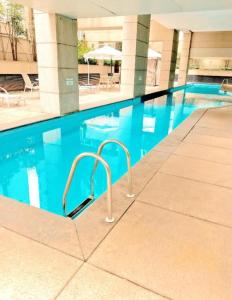 a swimming pool in a large building with blue water at São Paulo Mercure Moema Times Square - Flat DIAMOND in Sao Paulo