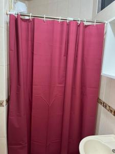 特魯希略的住宿－My House，浴室内有粉红色的淋浴帘和水槽