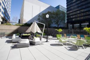 eine Terrasse mit Stühlen, Tischen und einem Sonnenschirm in der Unterkunft Great Condo for a Comfortable Stay @Crystal City in Arlington