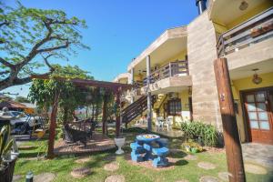 a patio in front of a building with blue chairs at Pousada Vila da Praia in Pinheira