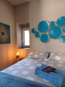 een slaapkamer met een bed met blauwe borden aan de muur bij DANTES in Pieve di Teco