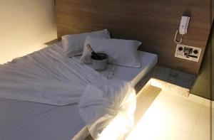 a large white bed in a room with a phone at Motel Queen in Lagoa Santa