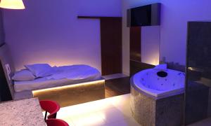 a bedroom with a bed and a tub in it at Motel Queen (Antigo Ícarus) in Lagoa Santa