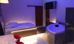 a bedroom with a bed and a tub in it at Motel Queen in Lagoa Santa