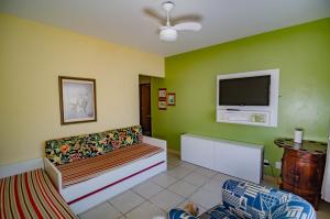 a living room with a couch and a flat screen tv at Pousada Vila da Praia in Pinheira