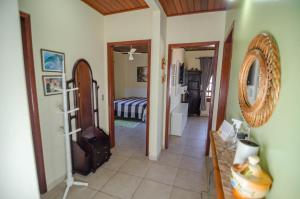 pasillo con habitación con cama y espejo en Pousada Vila da Praia en Pinheira